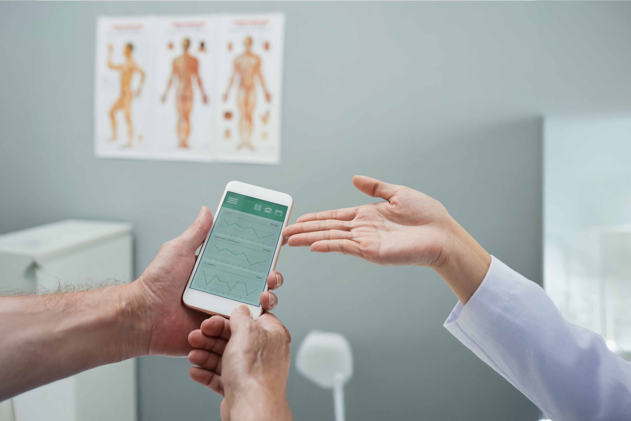 Digitale Gesundheitsanwendung - ein Arzt stellt einem Mann eine App vor und zeigt mit der offenen Hand darauf